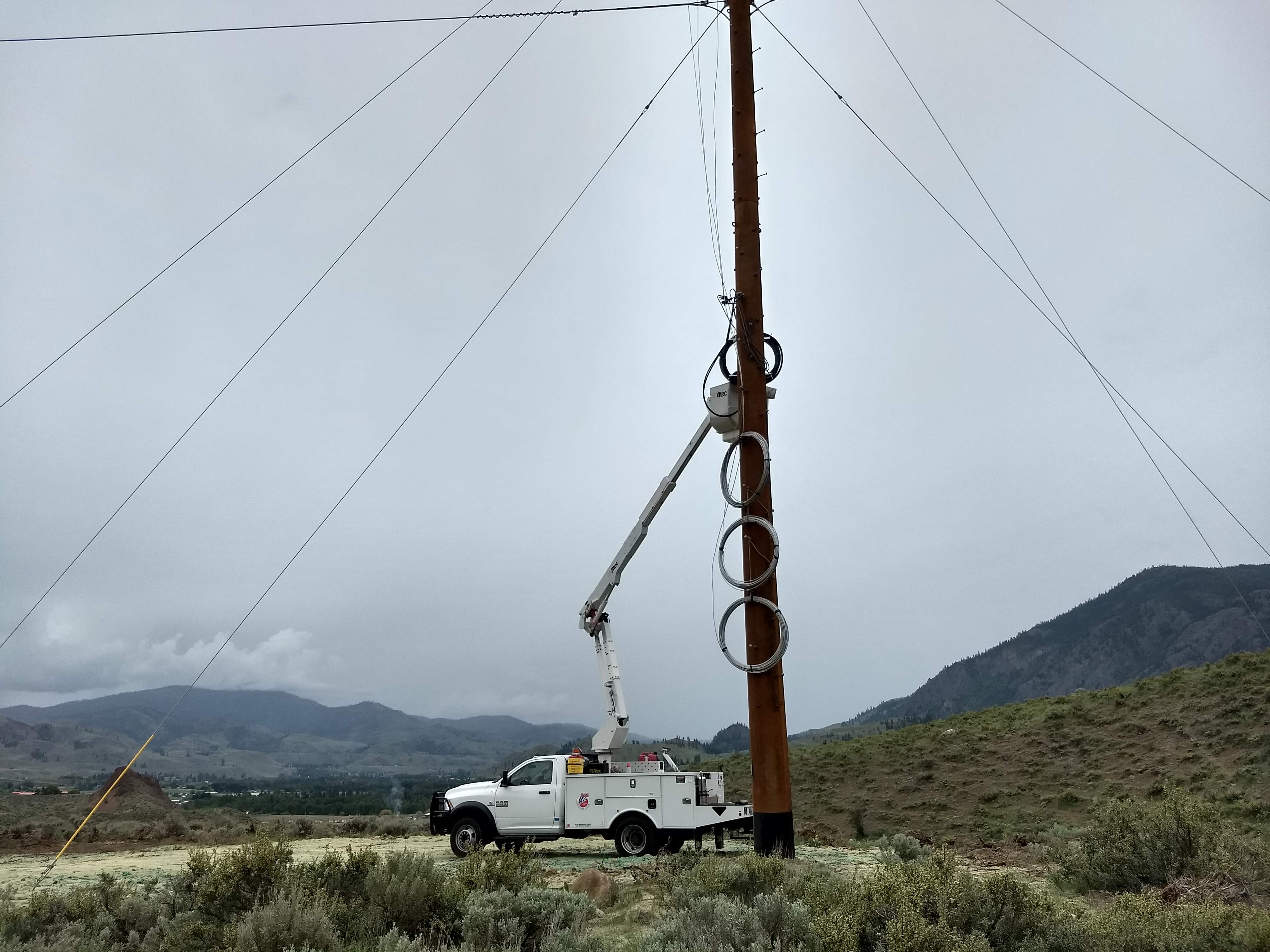 Hanging fiber optics on a power pole with bucket truck